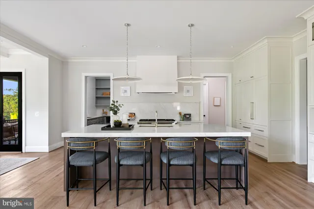a kitchen with a stove sink and living room view