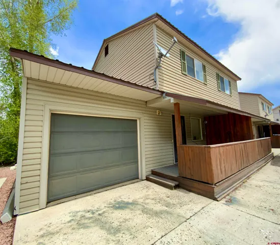 a view of house with garage and balcony