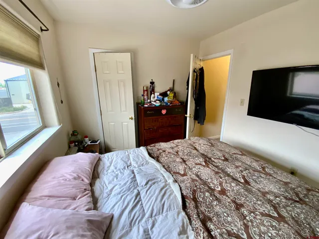 a bedroom with a bed and a flat screen tv