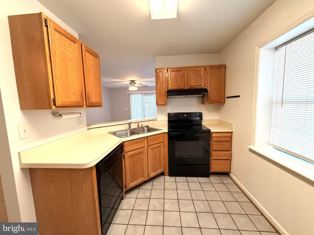a kitchen with a sink a stove top oven and cabinets