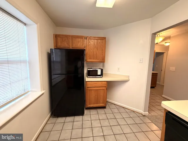 a kitchen with a refrigerator and a stove top oven