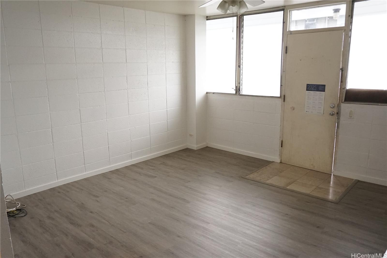1209 Kokea Street, Unit F203 Honolulu, HI 96817 - Photo 6 of 14 an empty room with wooden floor and windows
