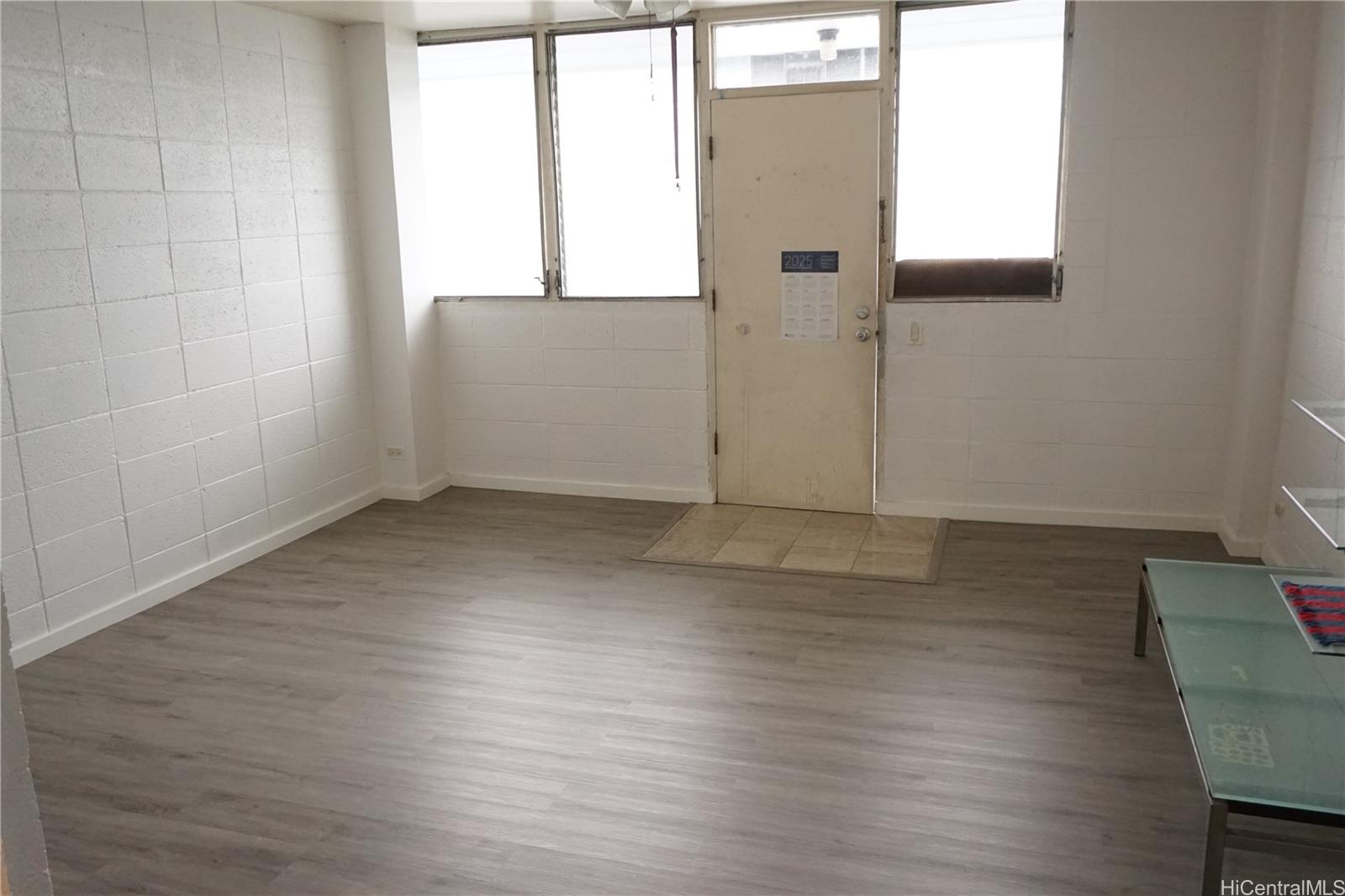 1209 Kokea Street, Unit F203 Honolulu, HI 96817 - Photo 7 of 14 an empty room with wooden floor and windows