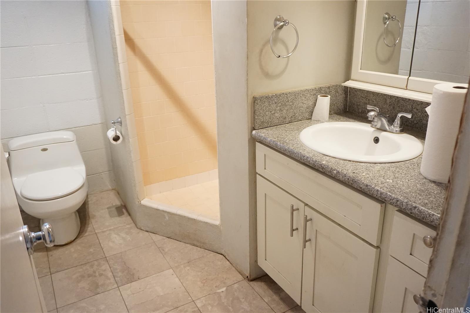 1209 Kokea Street, Unit F203 Honolulu, HI 96817 - Photo 8 of 14 a bathroom with a granite countertop sink a toilet and a mirror