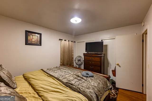 a bedroom with a bed and a flat screen tv