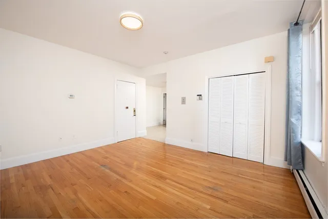 a view of empty room with wooden floor