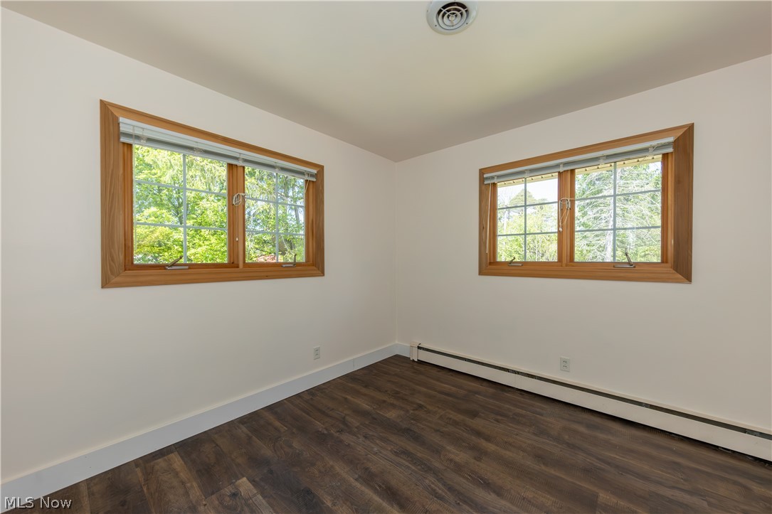 7969 Dines Road Novelty, OH 44072 - Photo 26 of 48 Bedroom with dark wood-finish flooring, two large windows with natural wood frames, and white trim