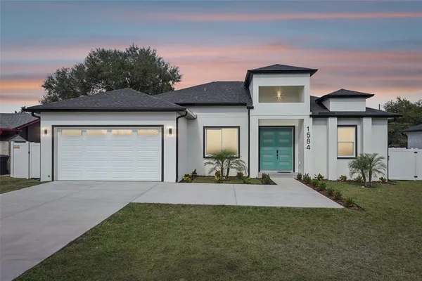 a front view of a house with a yard and garage