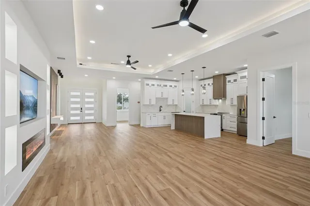 a kitchen with stainless steel appliances granite countertop a refrigerator sink and white cabinets