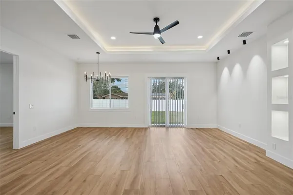 a view of empty room with wooden floor and ceiling fan
