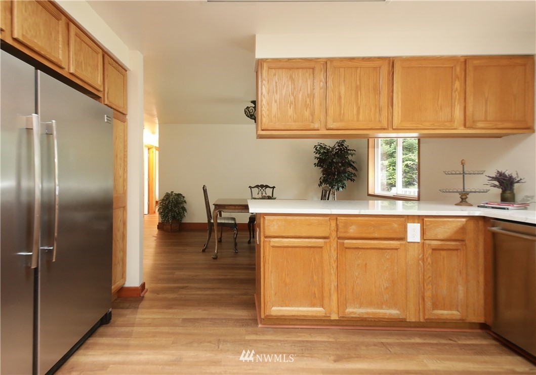 6416 Wahl Road Freeland, WA 98249 - Photo 13 of 40 a kitchen with stainless steel appliances granite countertop a refrigerator and a sink
