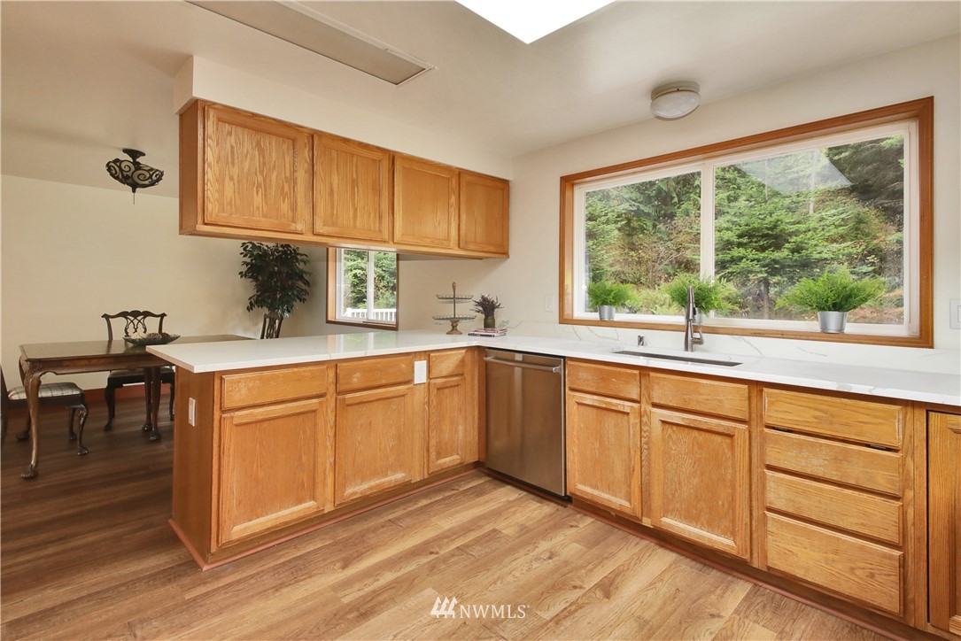 6416 Wahl Road Freeland, WA 98249 - Photo 15 of 40 a kitchen with stainless steel appliances granite countertop white cabinets sink and a large window