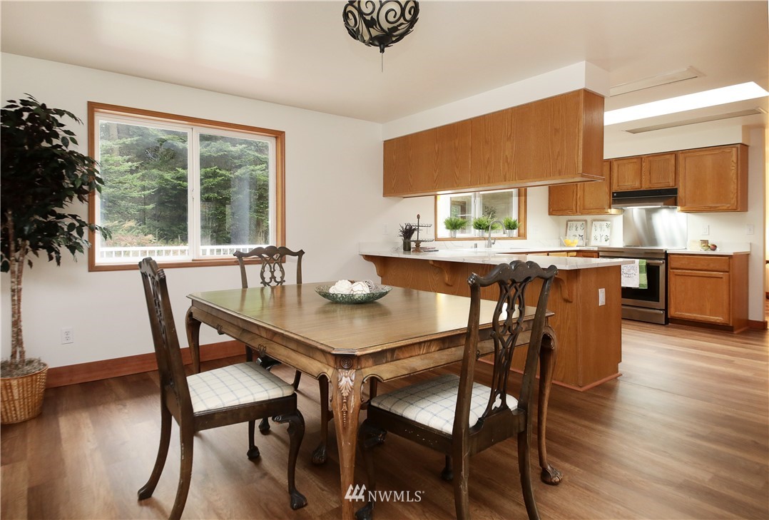 6416 Wahl Road Freeland, WA 98249 - Photo 17 of 40 a dining room with furniture a window and wooden floor