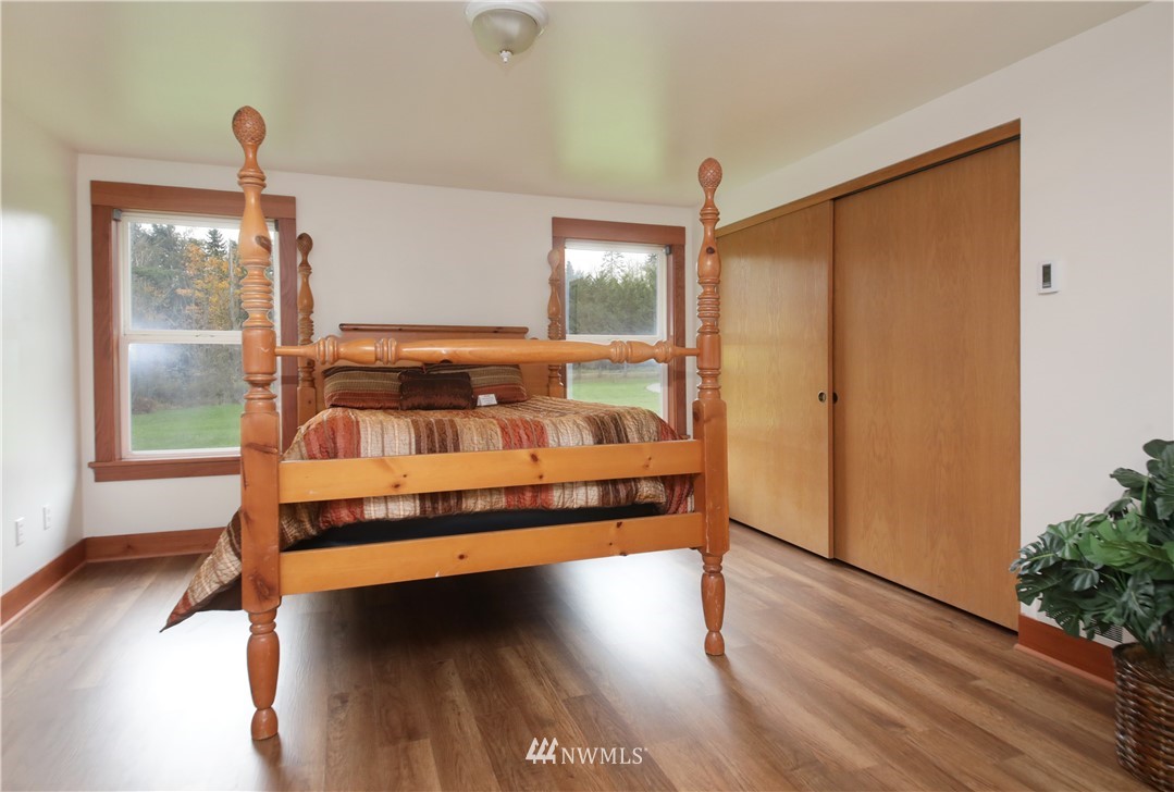 6416 Wahl Road Freeland, WA 98249 - Photo 18 of 40 a bedroom with wooden floor and a window