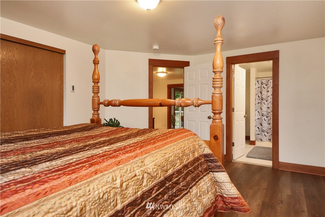 6416 Wahl Road Freeland, WA 98249 - Photo 19 of 40 a bedroom with a bed and wooden floor