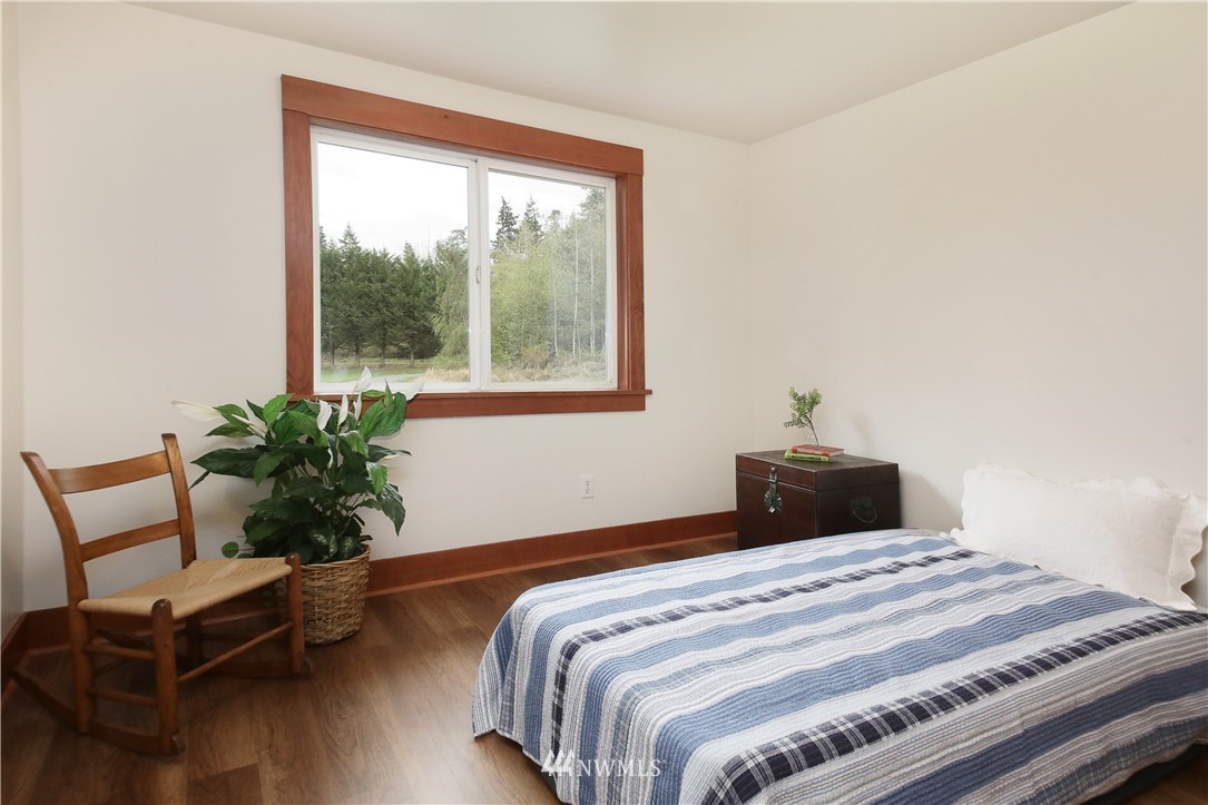 6416 Wahl Road Freeland, WA 98249 - Photo 22 of 40 a bedroom with bed window and wooden floor