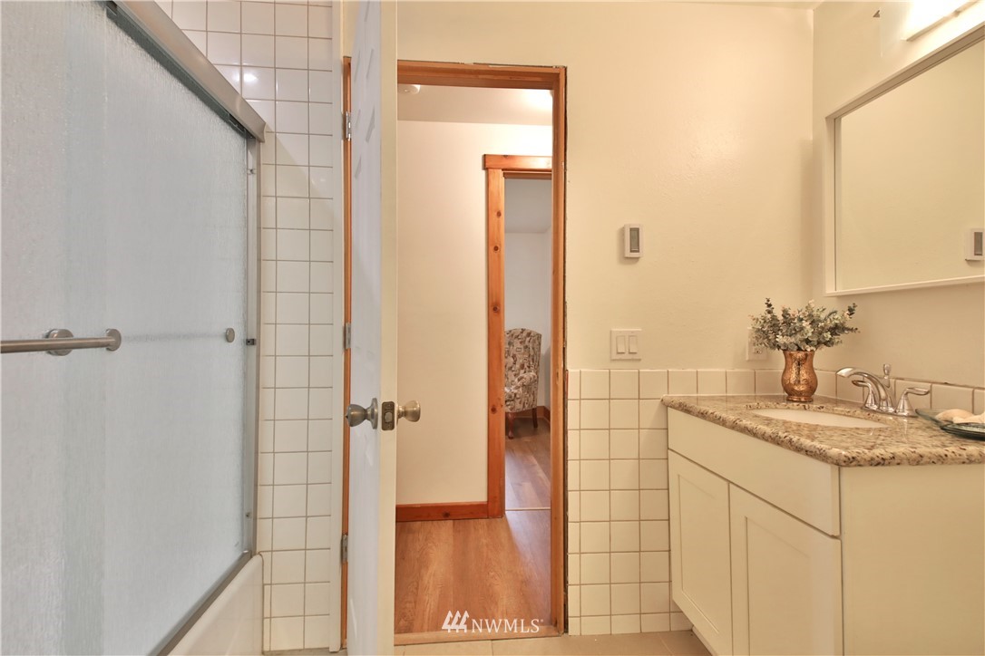 6416 Wahl Road Freeland, WA 98249 - Photo 27 of 40 a bathroom with a granite countertop sink a shower and a mirror