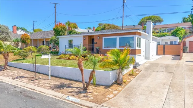 a front view of a house with a yard and potted plants
