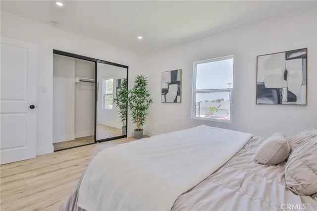 a bedroom with a large bed and a potted plant