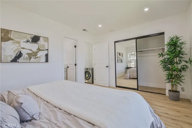 a bedroom with a large bed and a potted plant
