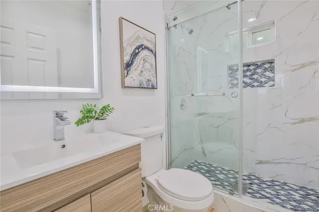 a bathroom with a sink a toilet and shower