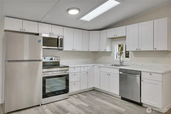 a kitchen with cabinets stainless steel appliances and a counter space