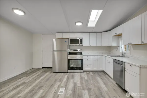 a kitchen with granite countertop a refrigerator and a stove top oven