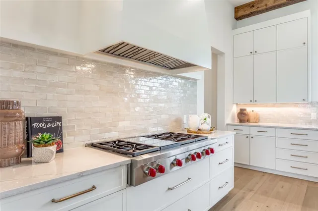 a kitchen with a stove and white cabinets
