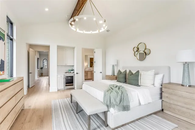 a bedroom with a large bed and a chandelier