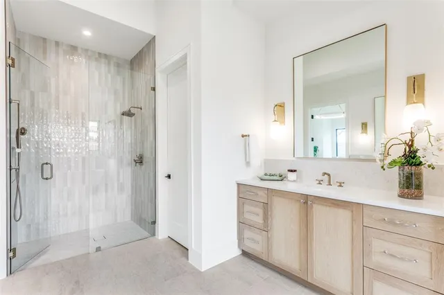 a bathroom with a double vanity sink mirror and shower