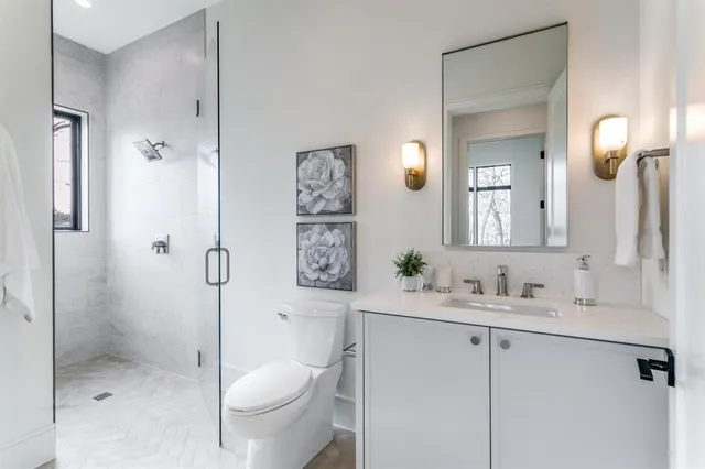 a bathroom with a granite countertop sink toilet and shower