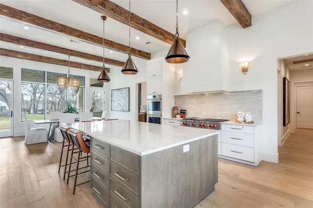 a large kitchen with kitchen island a large island in it