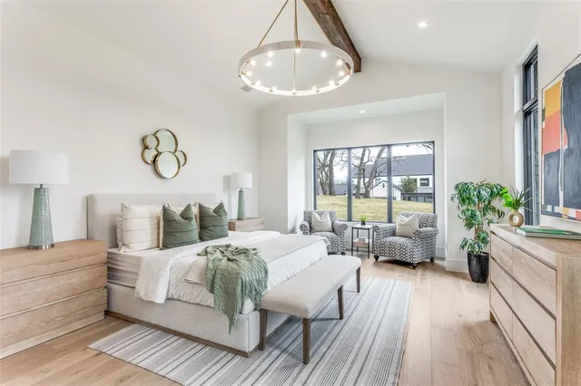 a bedroom with a large bed and a chandelier