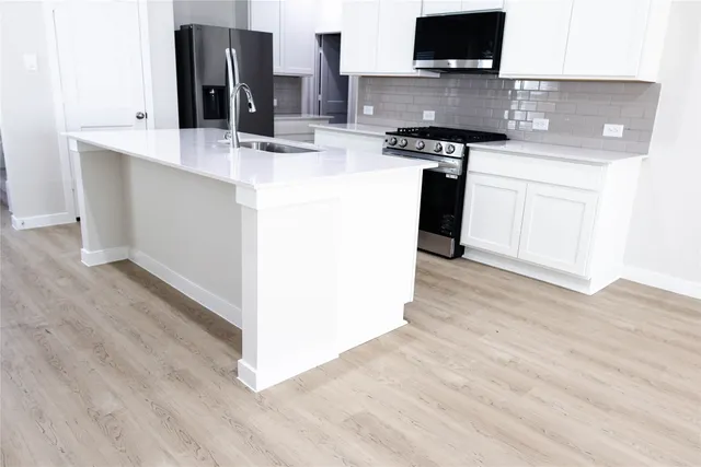 a kitchen with stainless steel appliances granite countertop a sink and a stove