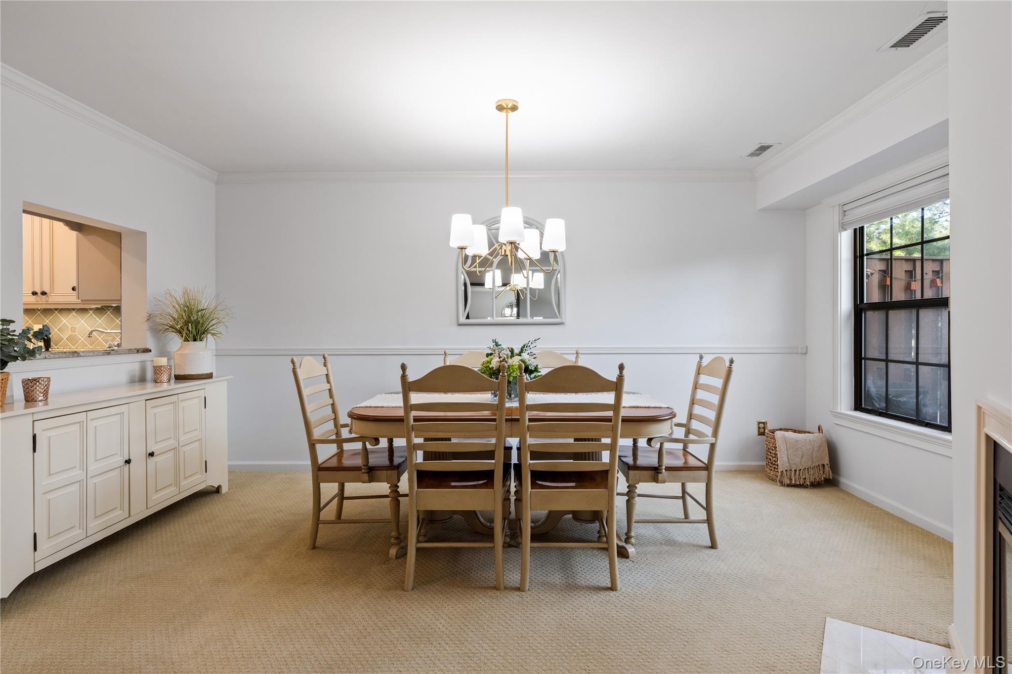 17 Sutton Place Islip, NY 11751 - Photo 14 of 32 Dining area featuring ornamental molding, light colored carpet, and a chandelier