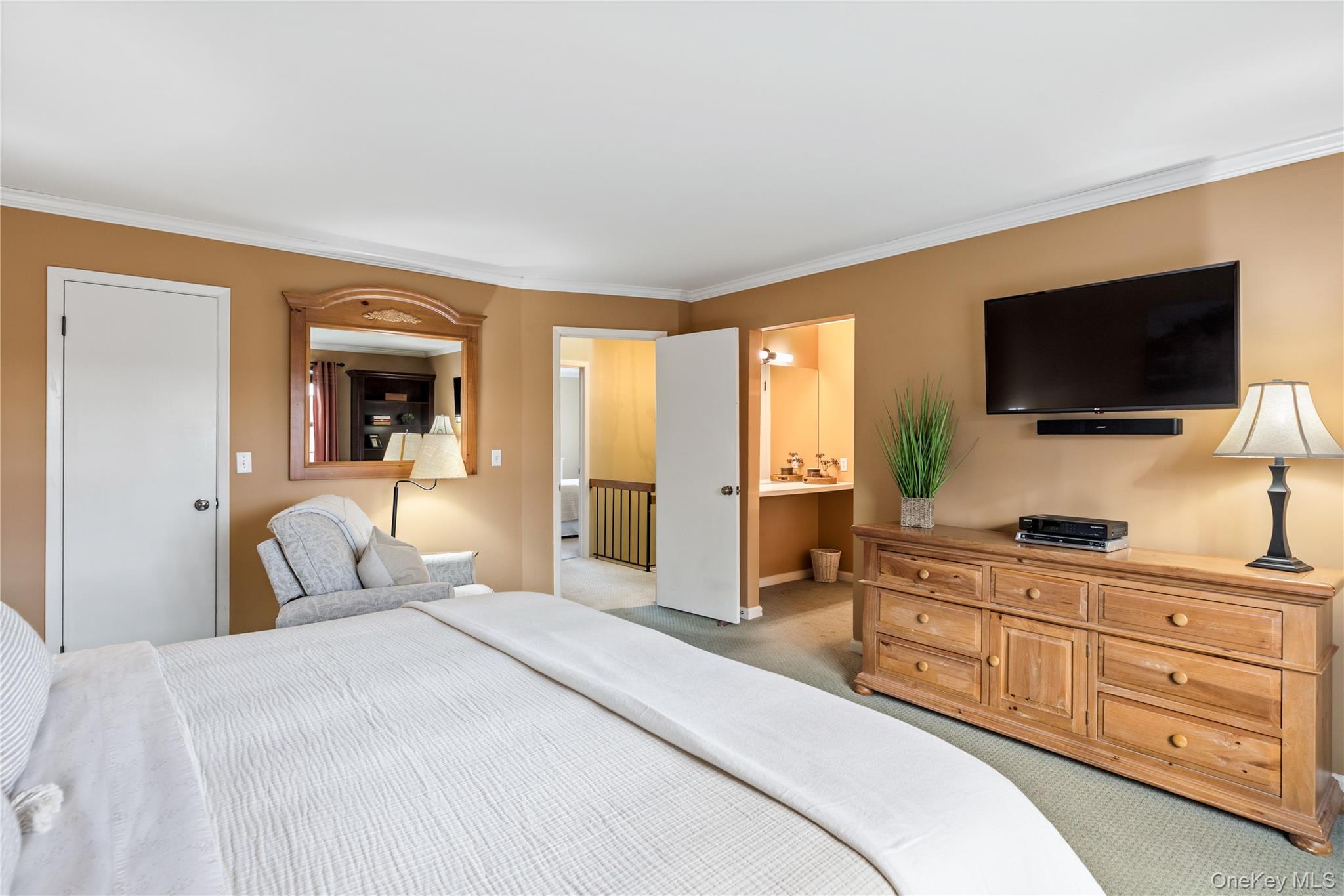 17 Sutton Place Islip, NY 11751 - Photo 20 of 32 Bedroom with light carpet, crown molding, and connected bathroom