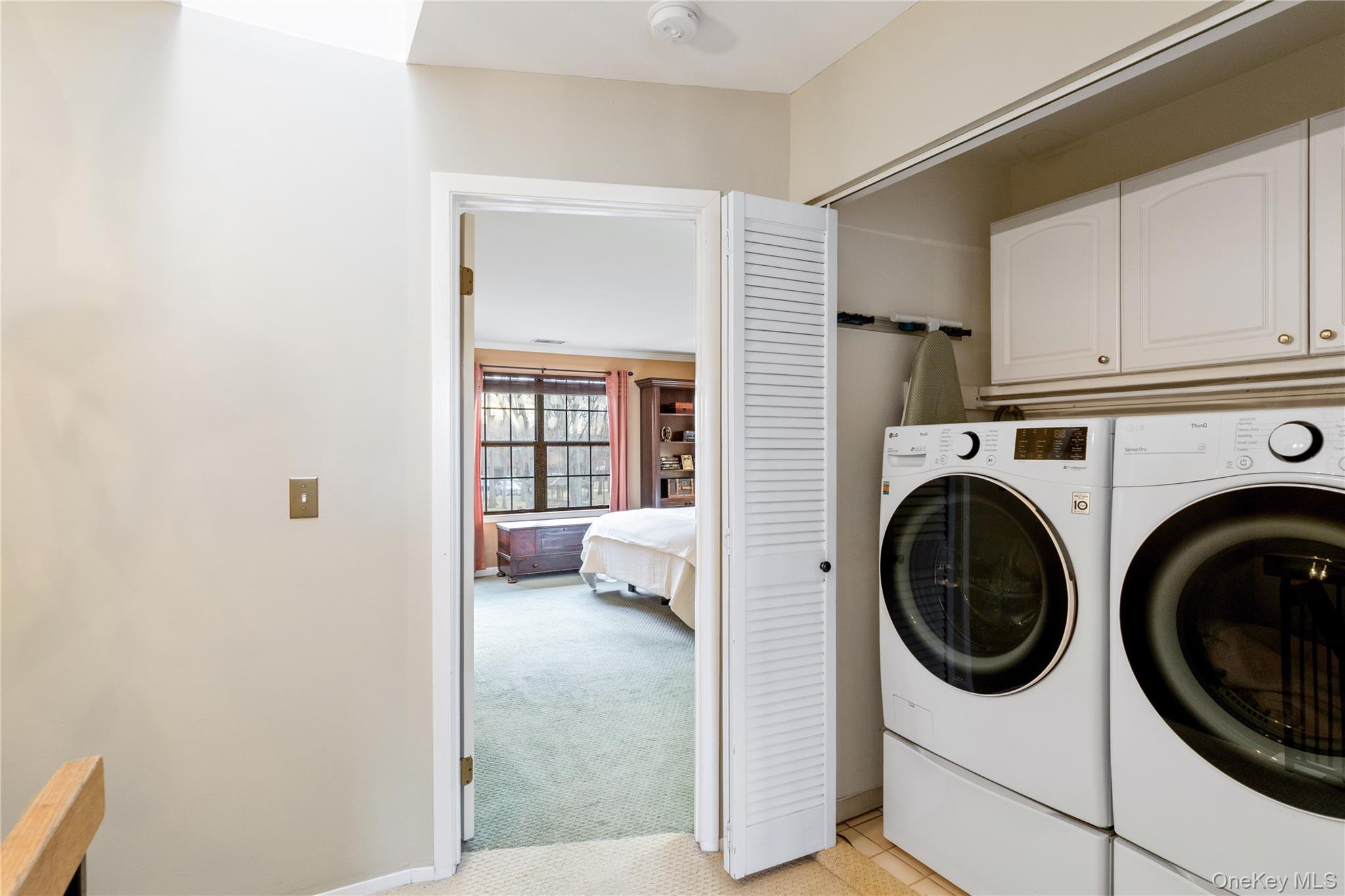 17 Sutton Place Islip, NY 11751 - Photo 23 of 32 Laundry room with light colored carpet and washer and clothes dryer