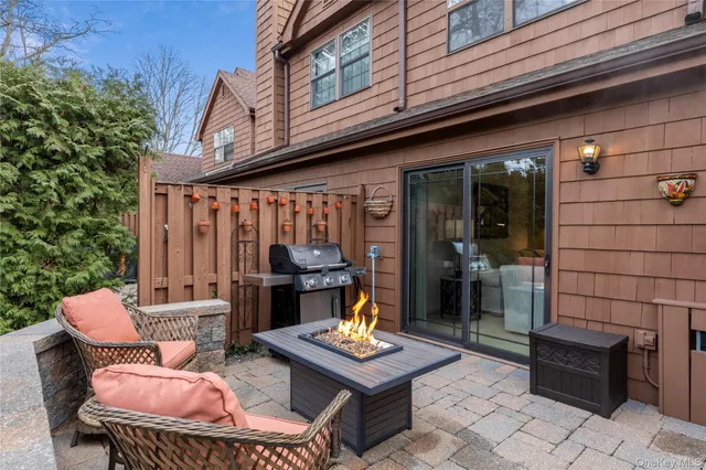 a backyard of a house with barbeque oven table and chairs