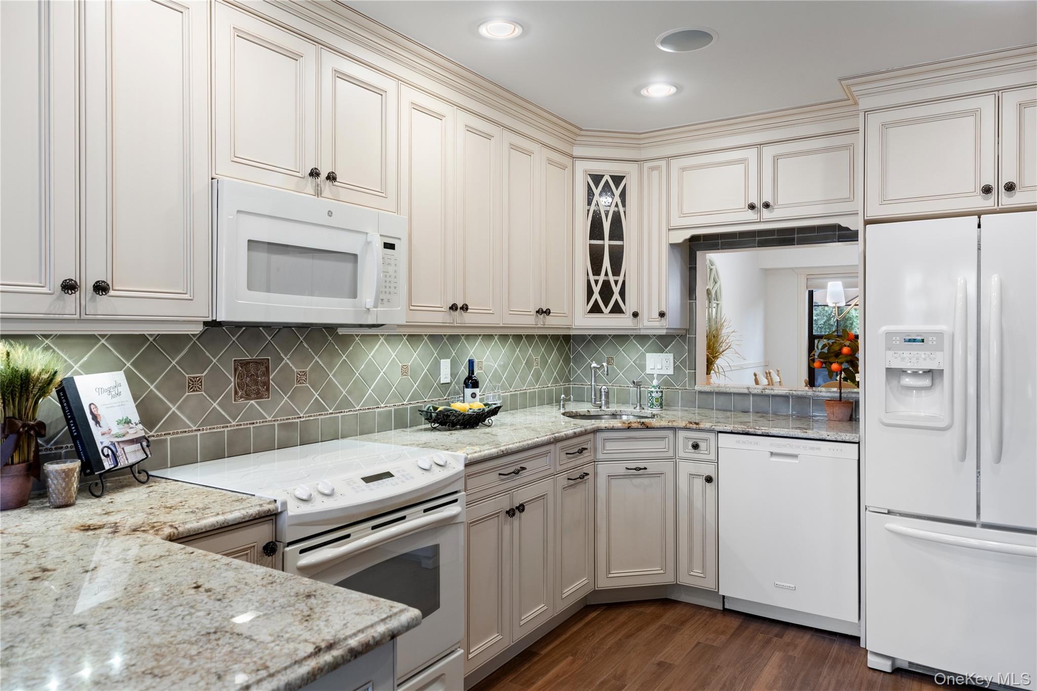 17 Sutton Place Islip, NY 11751 - Photo 6 of 32 Kitchen with white appliances, light stone counters, glass insert cabinets, dark wood-type flooring, and tasteful backsplash