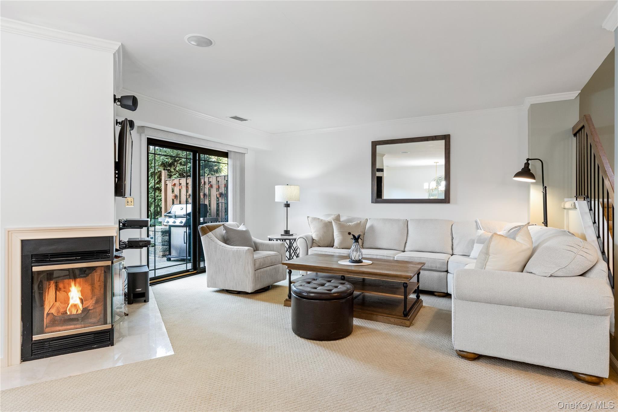 17 Sutton Place Islip, NY 11751 - Photo 8 of 32 Living area featuring a glass covered fireplace, ornamental molding, and carpet floors