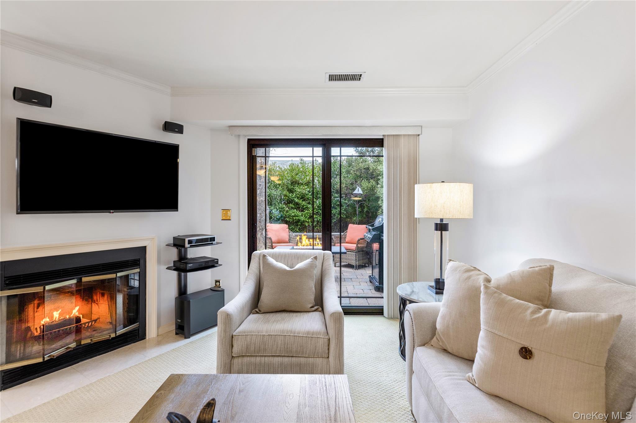 17 Sutton Place Islip, NY 11751 - Photo 10 of 32 Living area with a glass covered fireplace, crown molding, and carpet