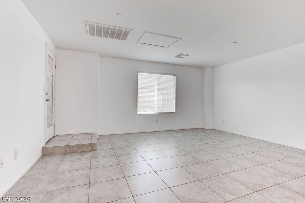 4650 Ranch House Road, Unit 47 North Las Vegas, NV 89031 - Photo 6 of 43 A well-lit, neutral living space features durable tile flooring and a window offering natural light.