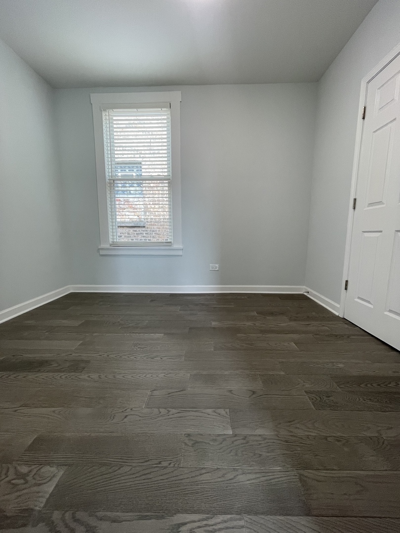 2416 North Springfield Avenue, Unit 2 Chicago, IL 60647 - Photo 6 of 9 an empty room with wooden floor and windows