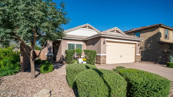 a front view of a house with a yard and potted plants