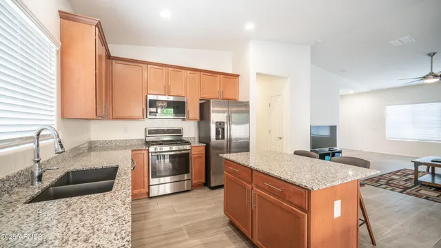 a kitchen with granite countertop a stove and a microwave