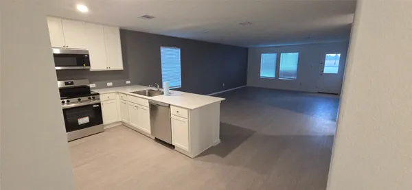 a kitchen with a stove sink and cabinets
