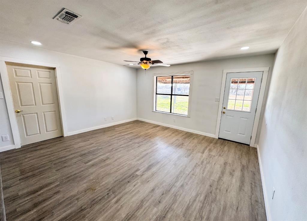119 Autumn Drive Early, TX 76802 - Photo 11 of 29 an empty room with wooden floor and windows