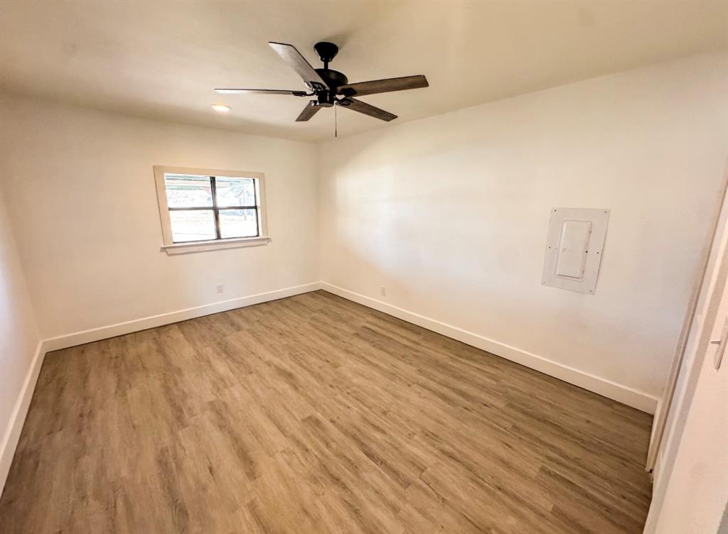 119 Autumn Drive Early, TX 76802 - Photo 15 of 29 an empty room with wooden floor fan and windows
