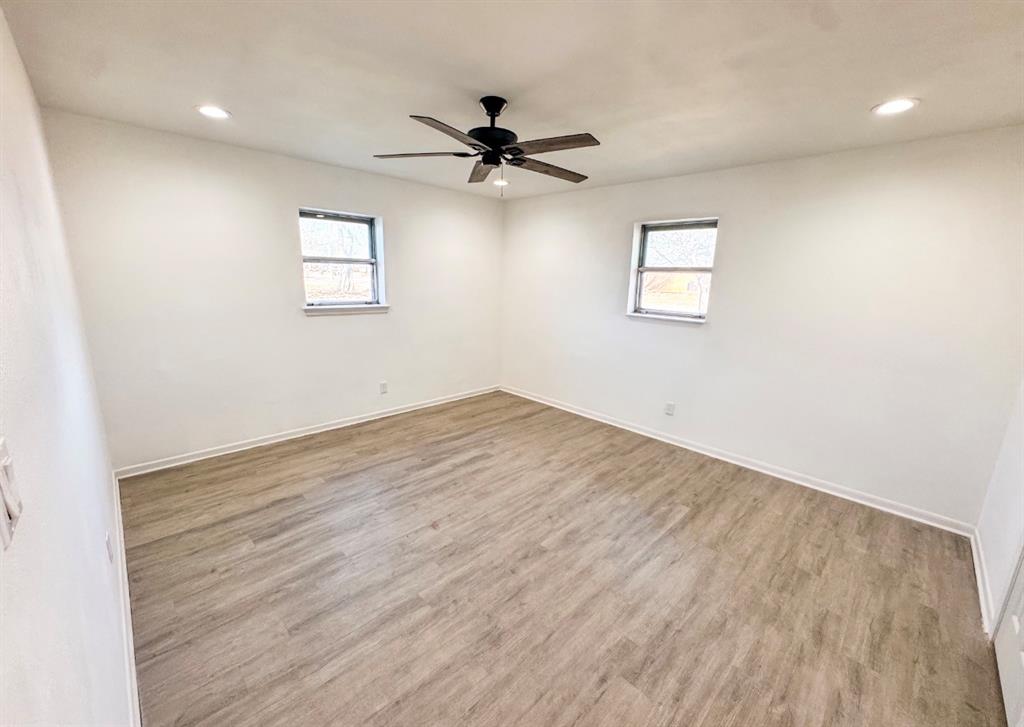119 Autumn Drive Early, TX 76802 - Photo 20 of 29 an empty room with wooden floor fan and windows