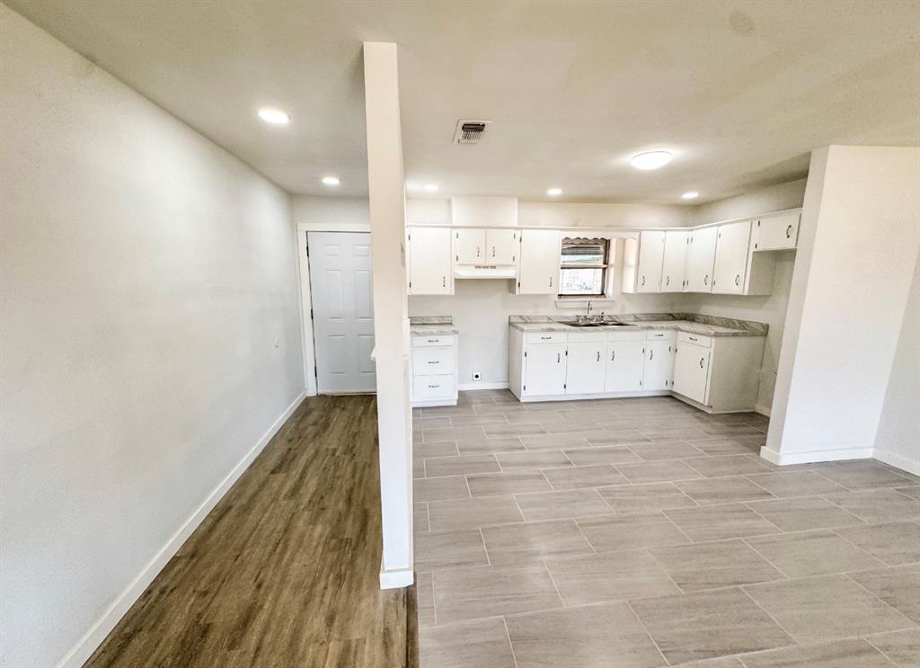 119 Autumn Drive Early, TX 76802 - Photo 5 of 29 a large kitchen with a wooden floor and stainless steel appliances